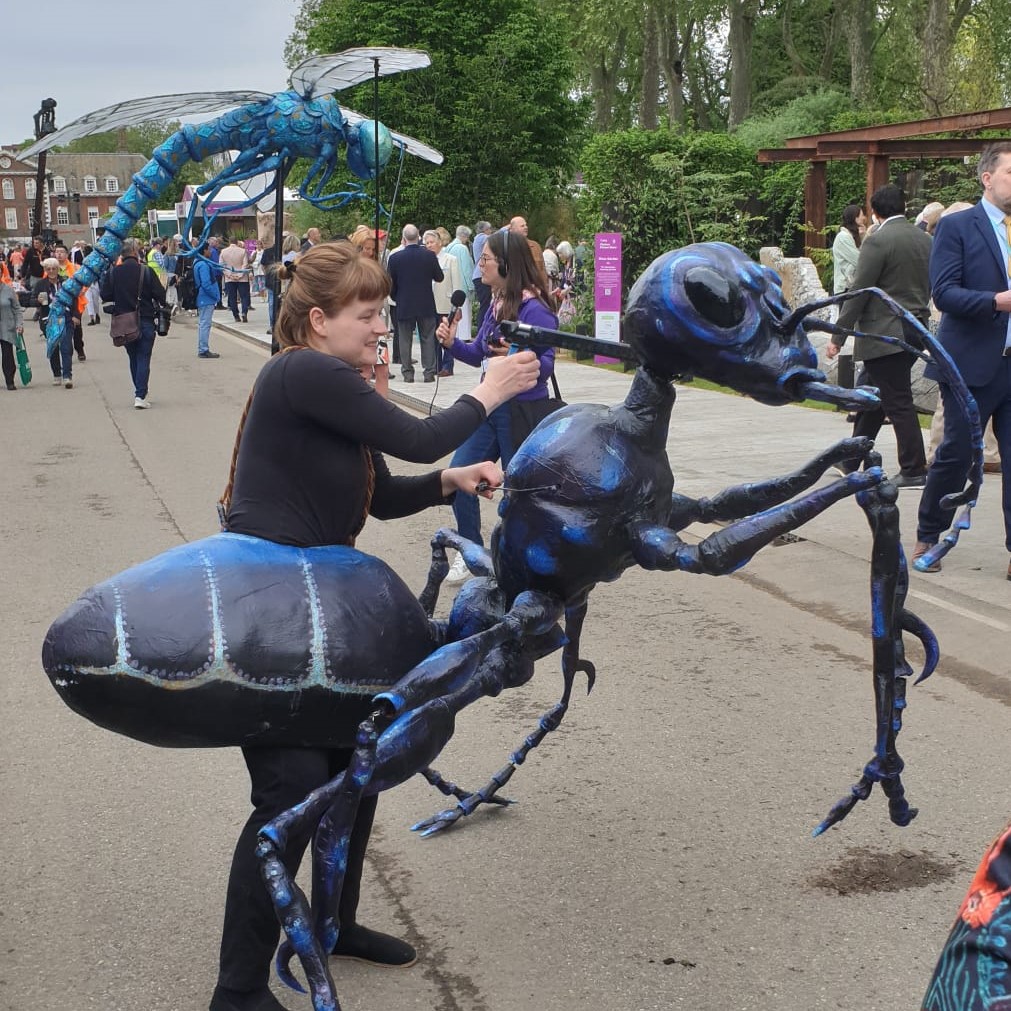 Giant ant and dragonfly puppets welcoming guests at the RHS Chelsea Flower Show