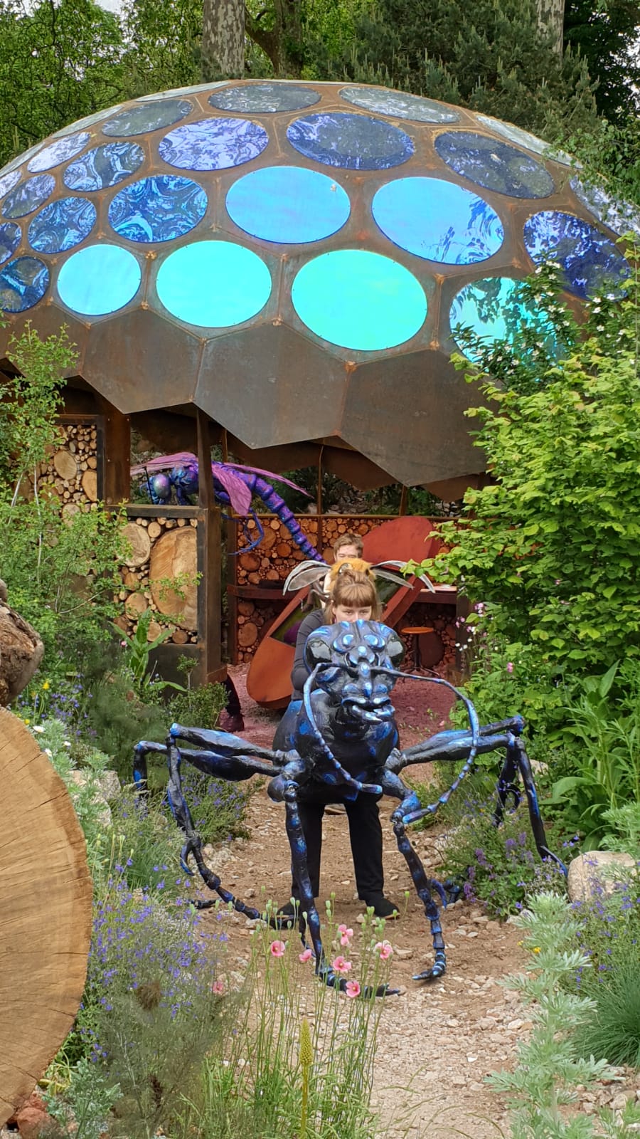 Giant ant and dragonfly puppets on the RES Garden at the RHS Chelsea Flower Show
